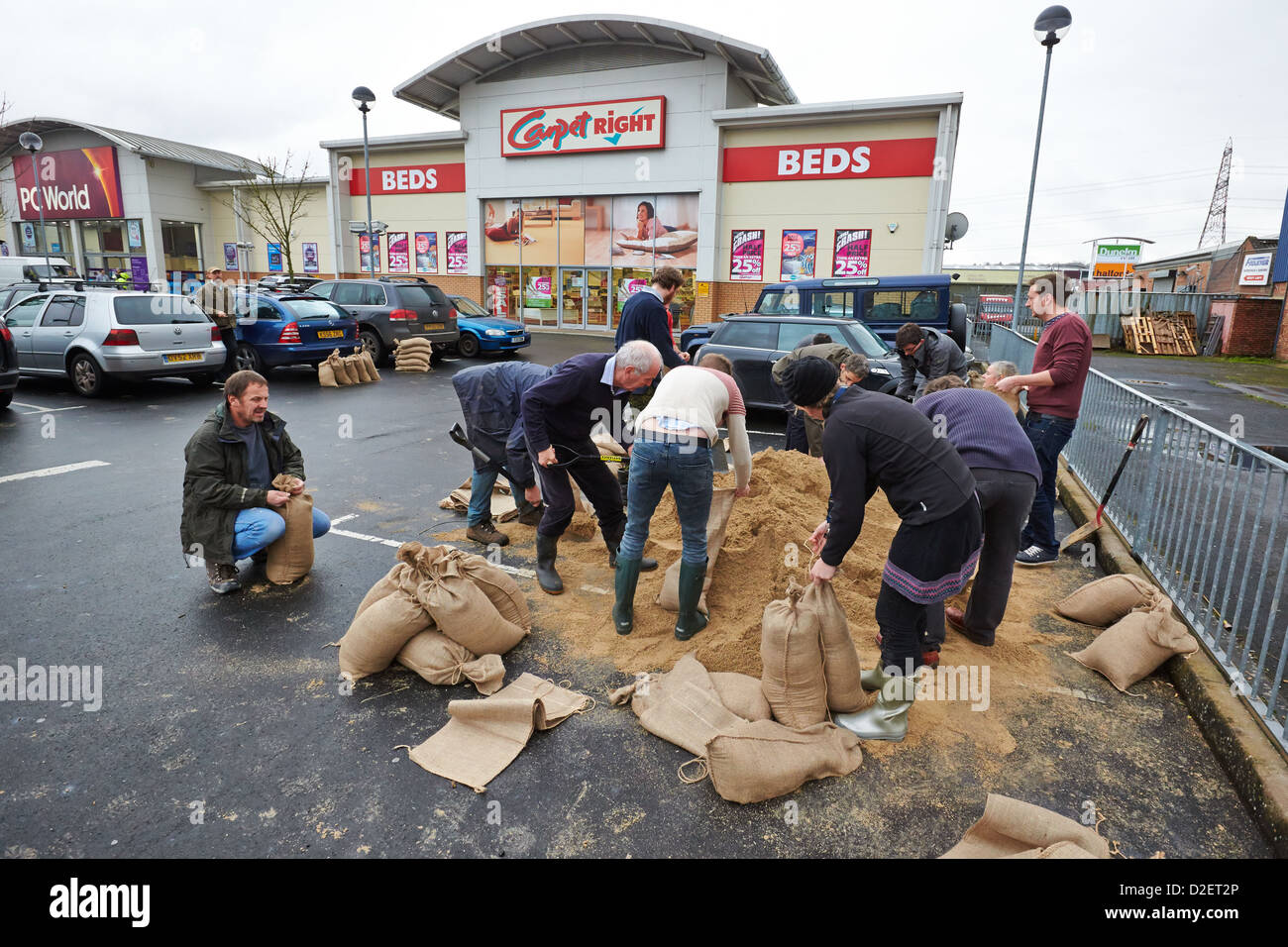 Residents fill sandbags in a retail car park using sand provided by the local council to protect
