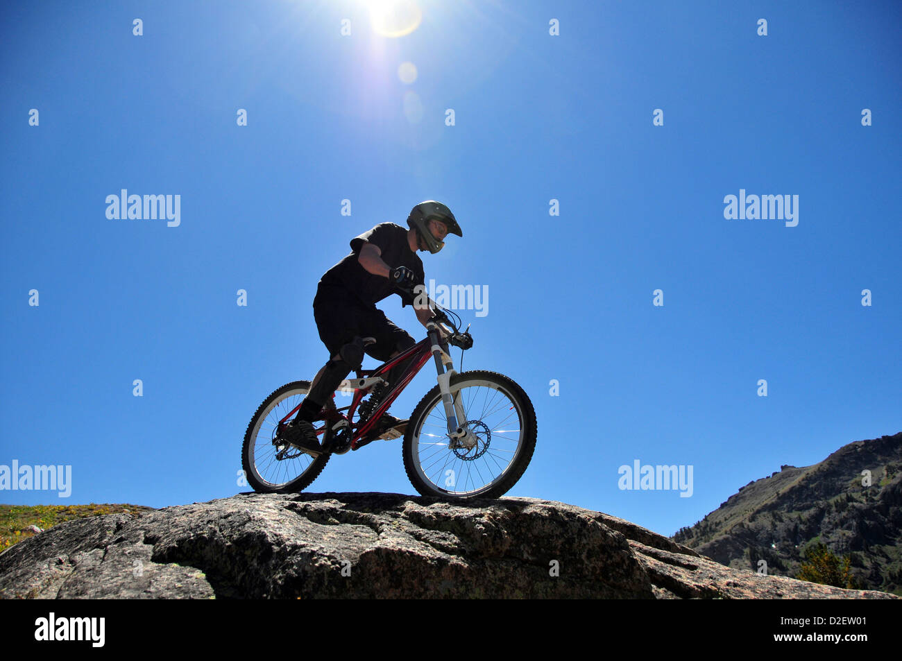 A mountain biker rides down a technical section of rock at Kirkwood Mountain Resort in the summer, CA. Stock Photo