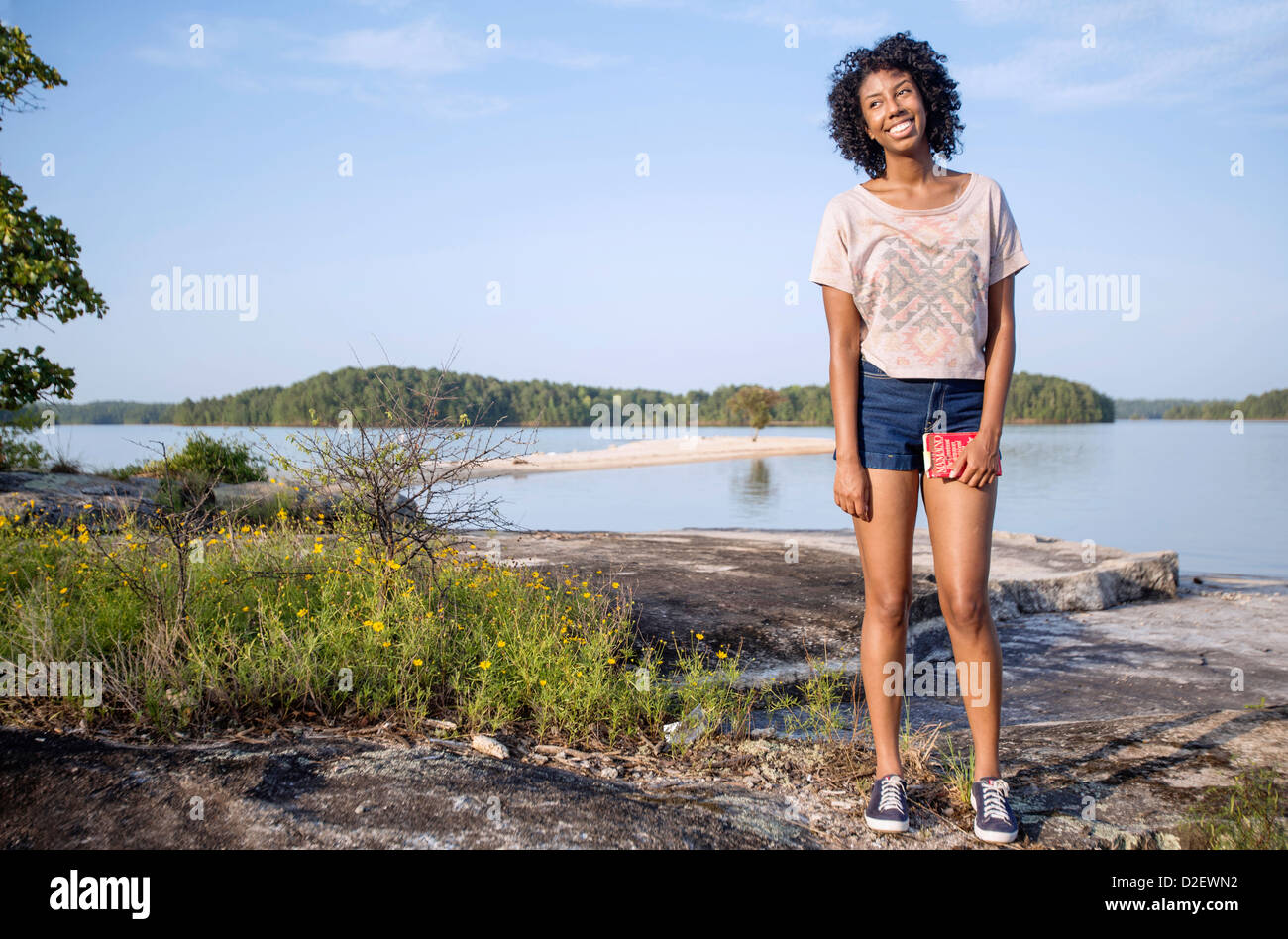 A young woman smiles while walking on the rocky shores of Lake Wedowee, AL  Stock Photo - Alamy