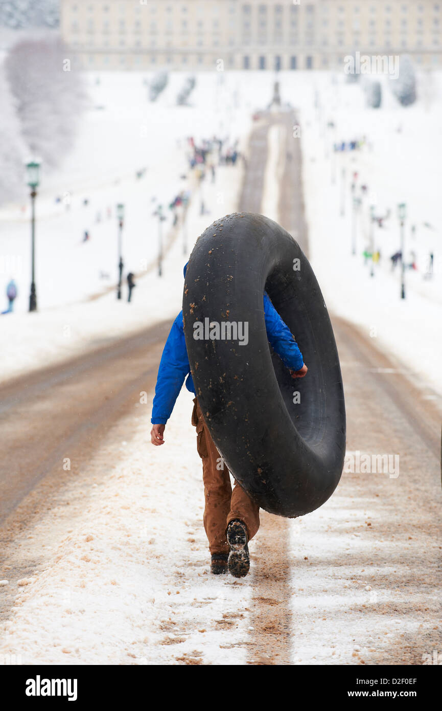 Man carrying a rubber inner tube for sledding on the snow, Stormont Estate Stock Photo