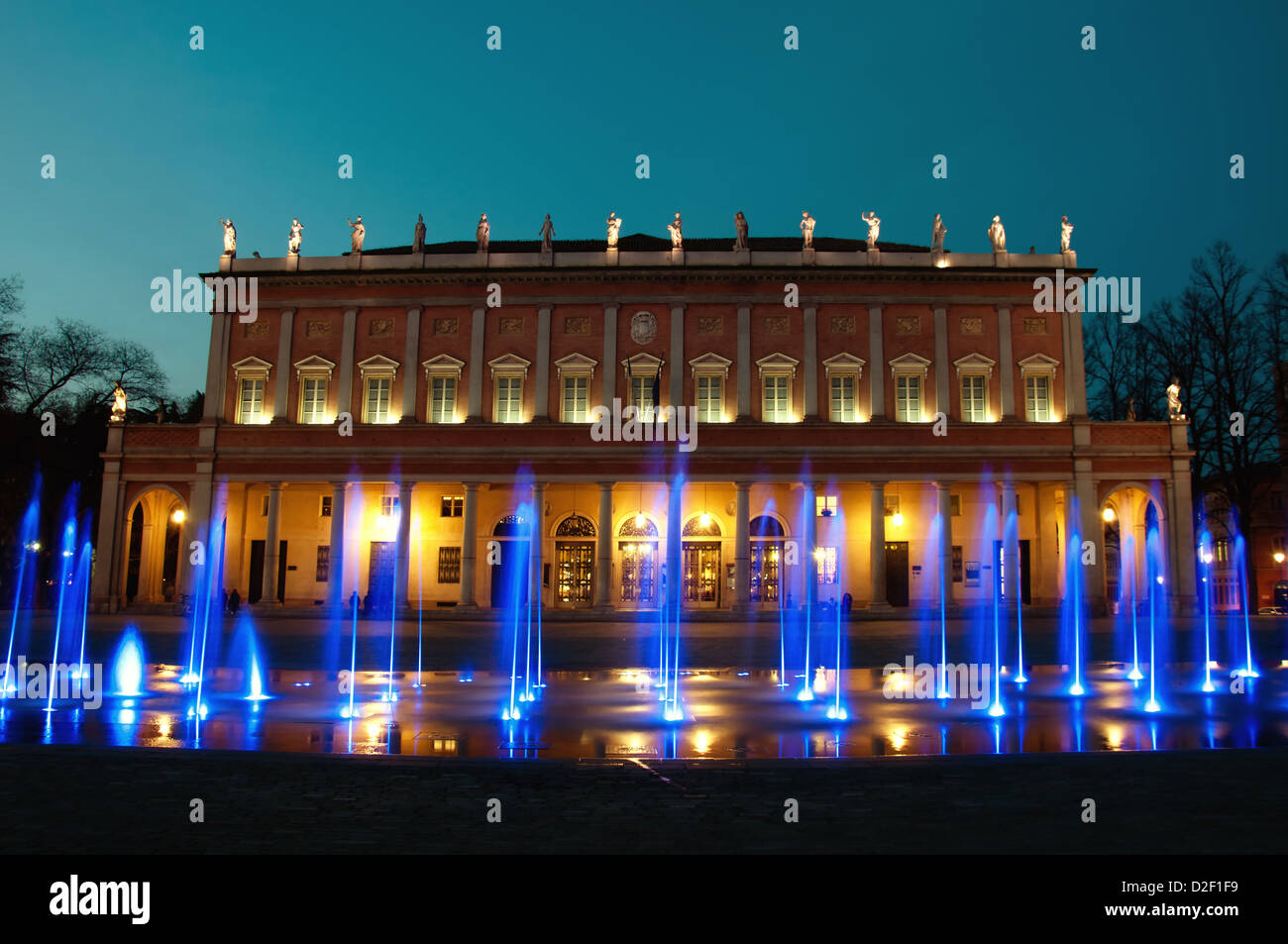 night view of 'Romolo Valli' Municipal Theater in Reggio Emilia, north of Italy, with enlightened modern fountain Stock Photo