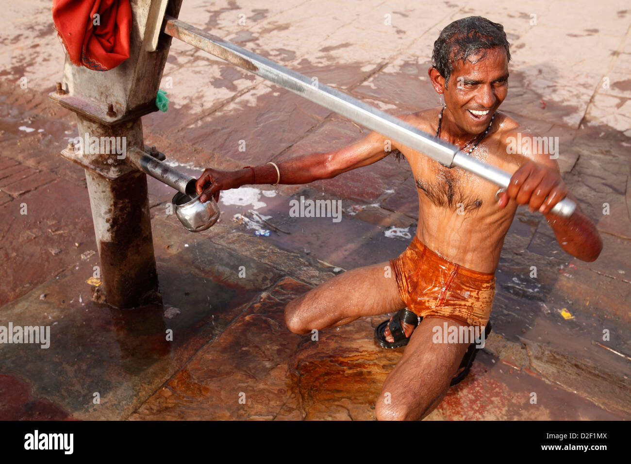 Man using a water pump for bathing . Mathurai. India. Stock Photo