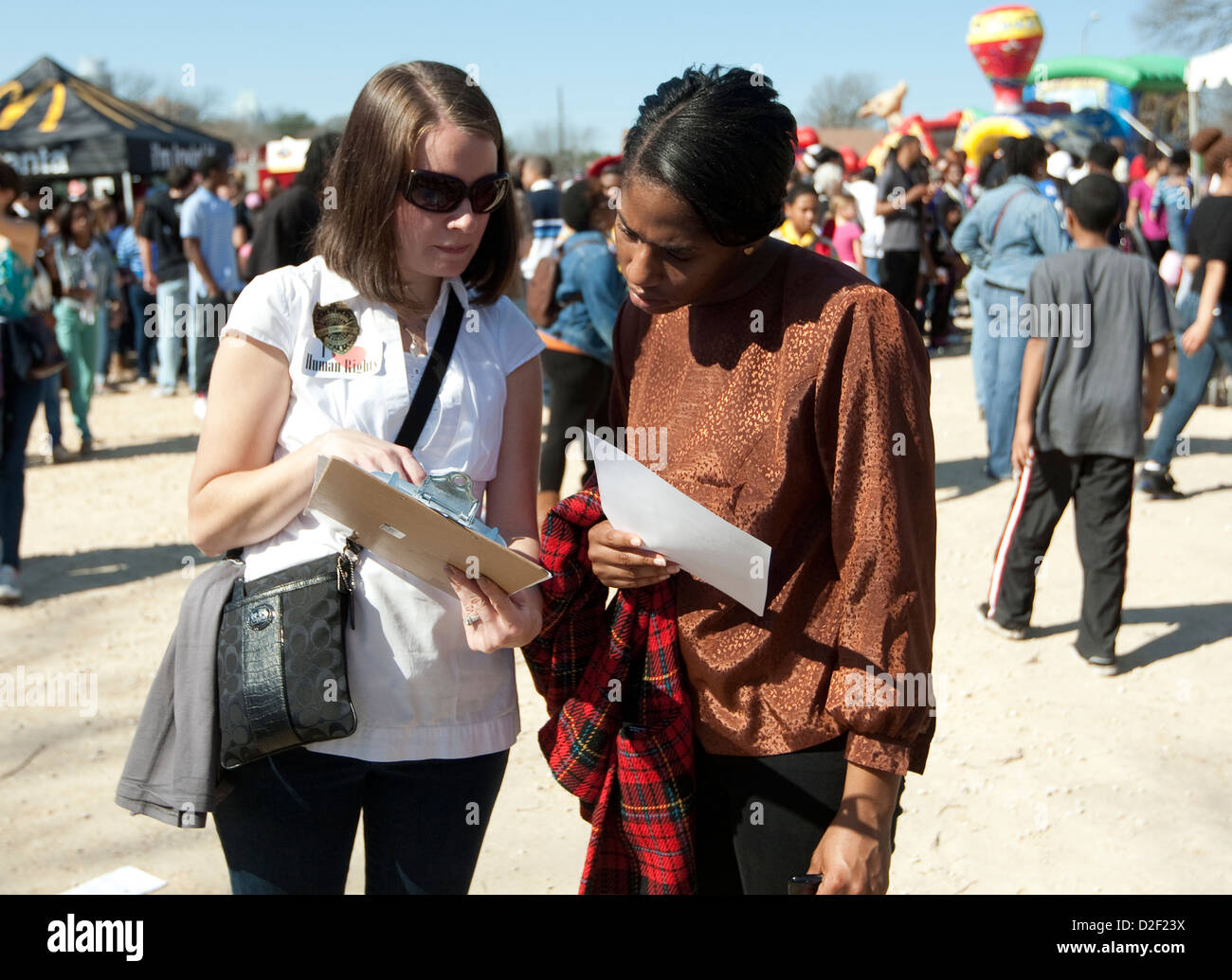 January 21st, 2013: White woman asks African-American to sign petition in favor of human rights at an MLK Jr. outdoor festival Stock Photo