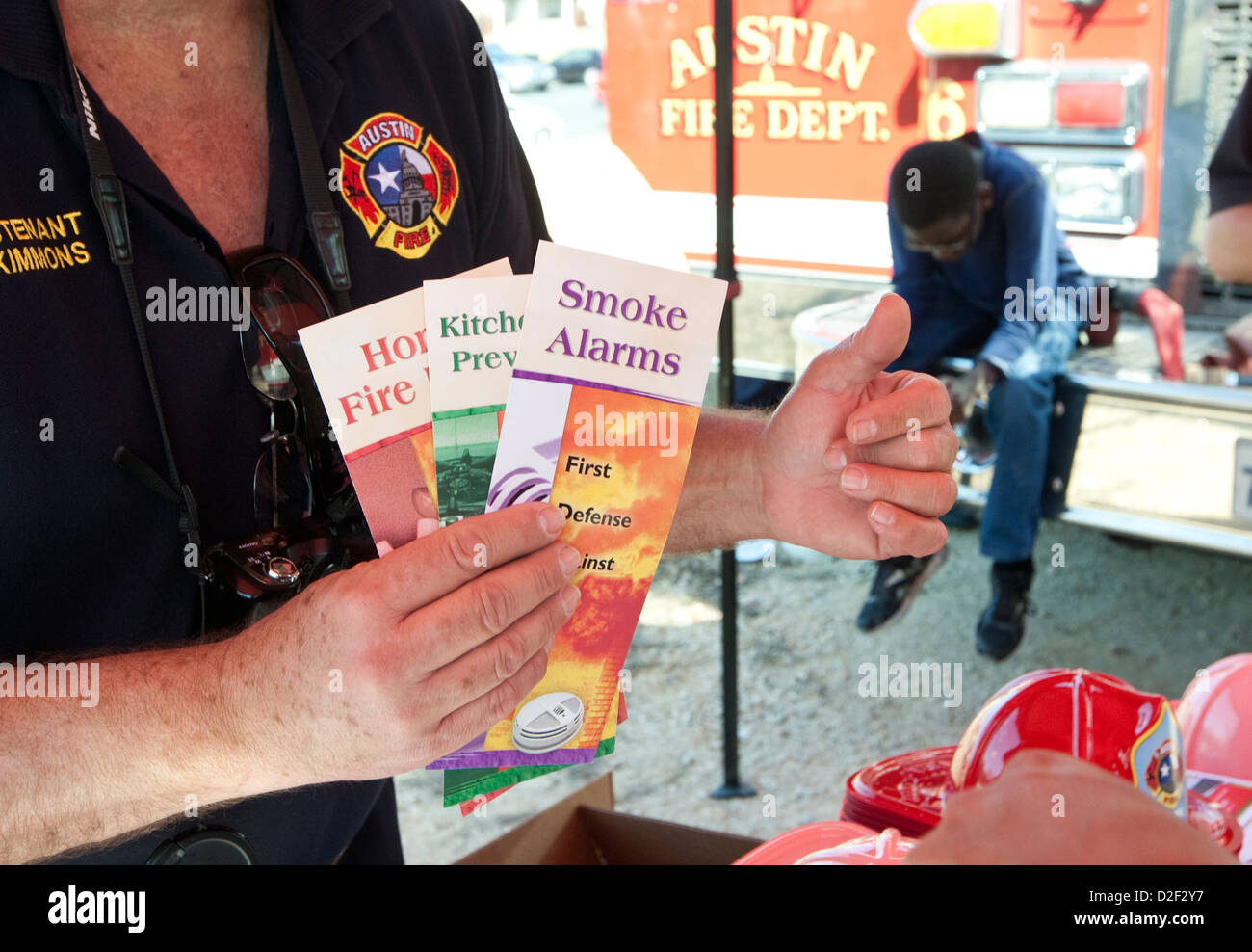 Firefighter hands out brochures on fire safety at an outdoor MLK festival in Austin, Texas Stock Photo