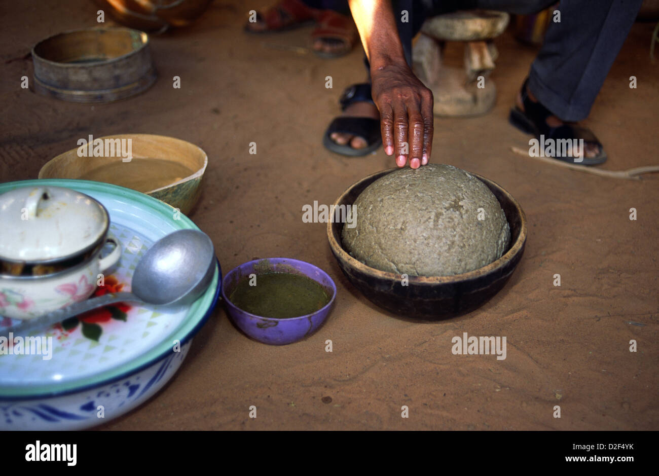 Meals are eaten with fingers in Mali, Africa. To is a millet-based dough eaten with a green okra sauce or gumbo Stock Photo