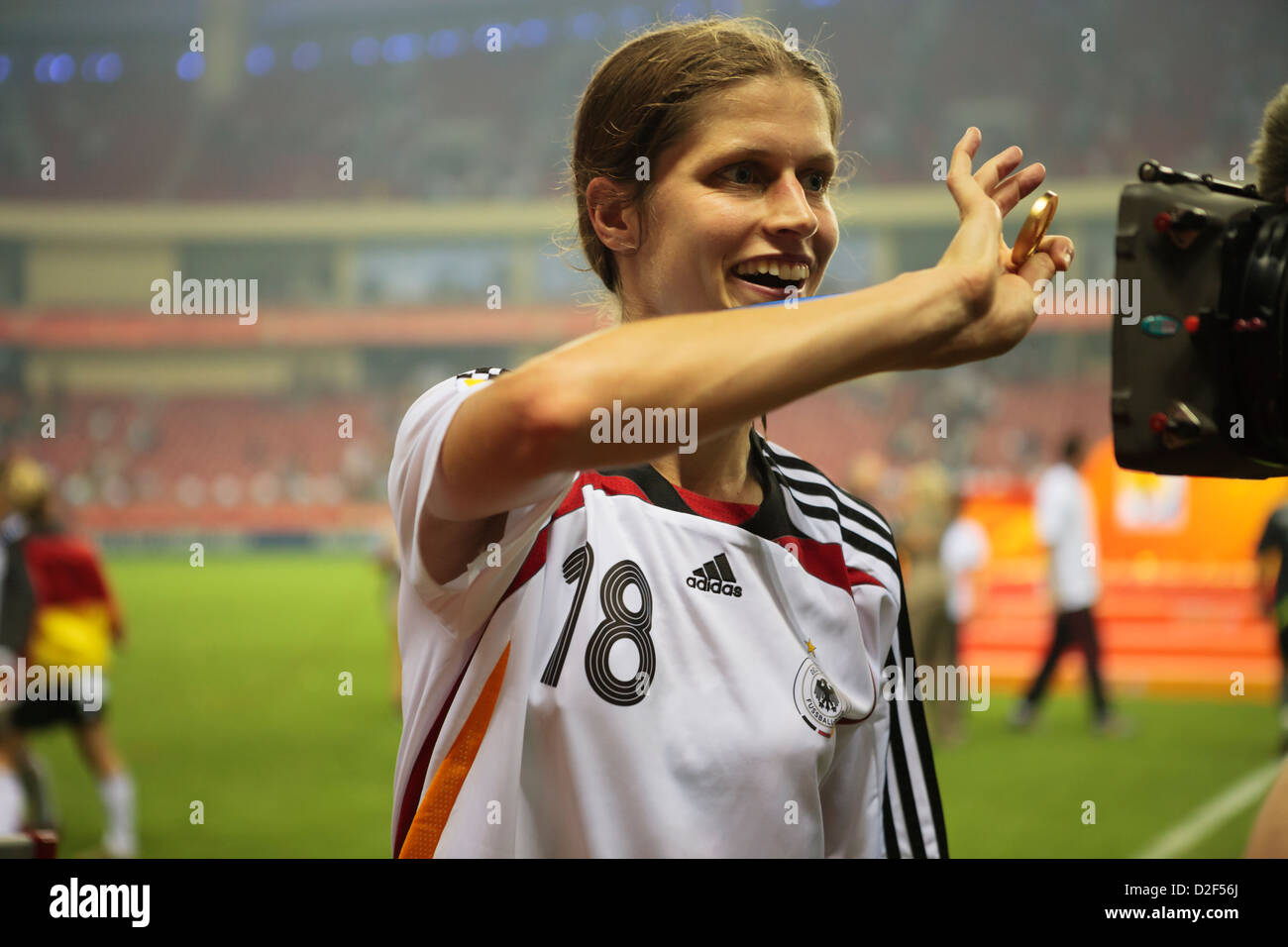 Kerstin Garefrekes of Germany shows off her gold medal to a television camera after Germany defeated Brazil for the Word Cup. Stock Photo