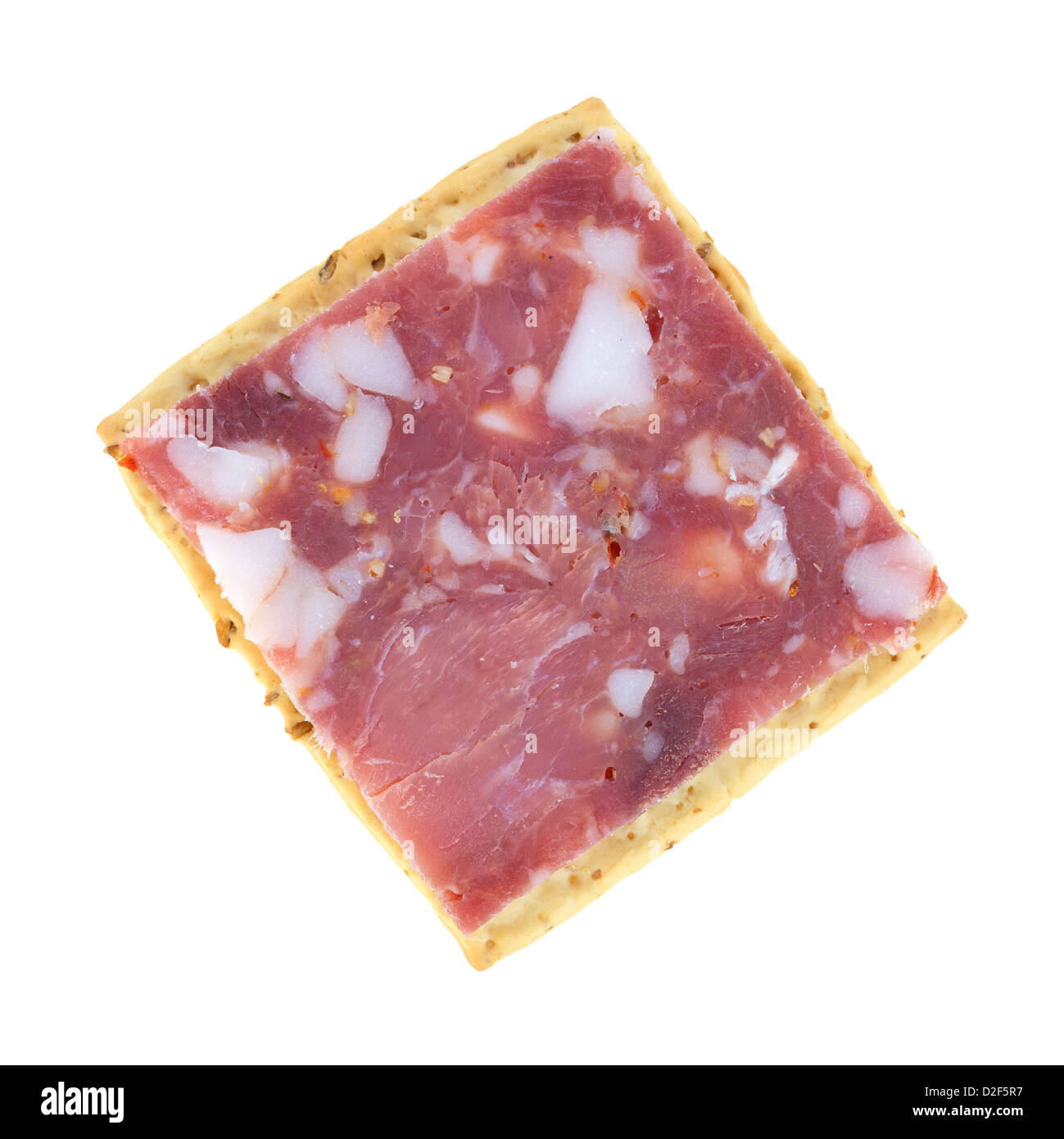 A square wheat cracker with a small slice of sopressata salami on a