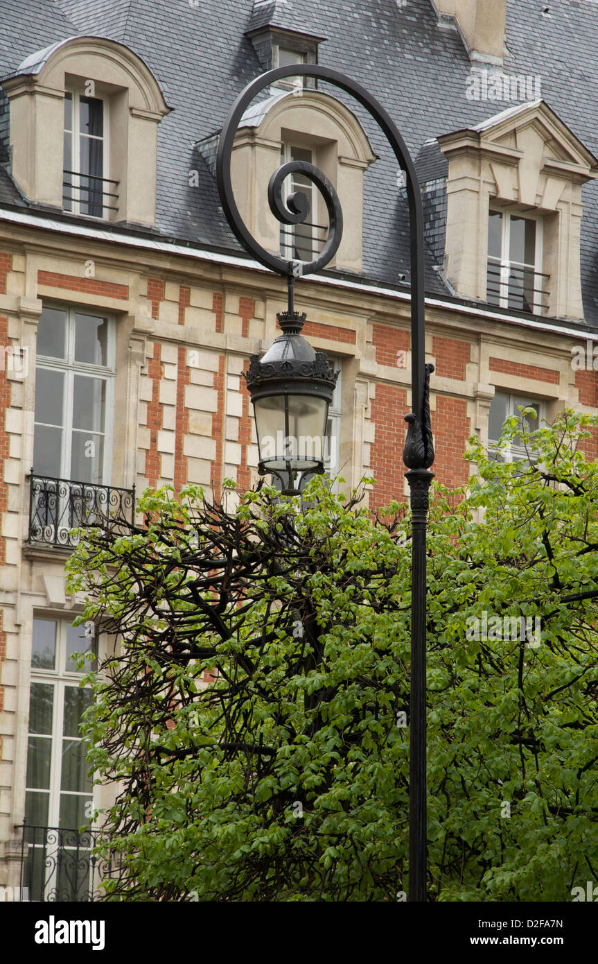 Elegant lantern. The exquisite Place des Vosges is the oldest planned square in Paris. Built by King Henri IV, it was inaugurated in 1612. France. Stock Photo