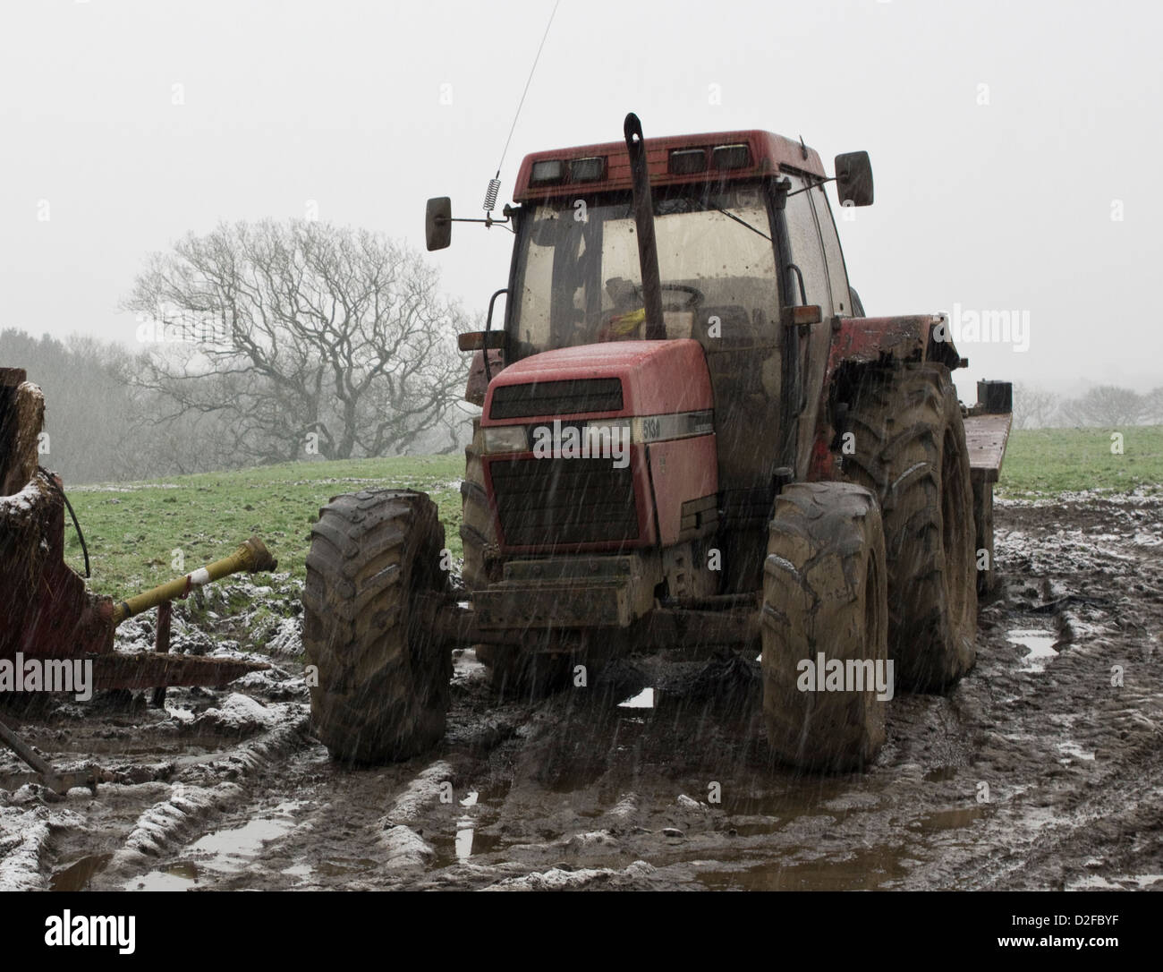 An agricultural tractor parked up in the farmers field in the snow. Stock Photo