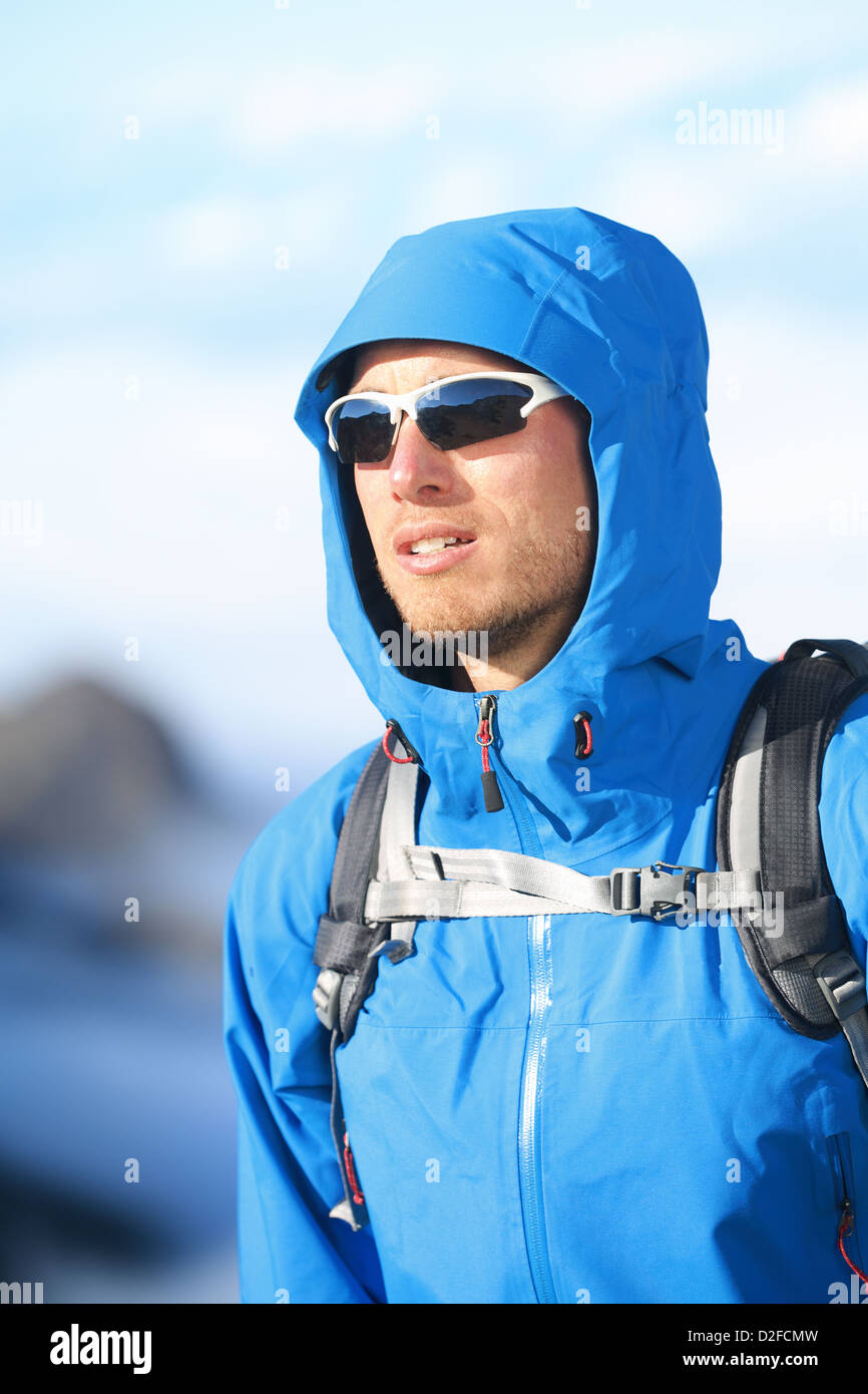 Handsome young male hiker alpine clothing hard shell jacket above in