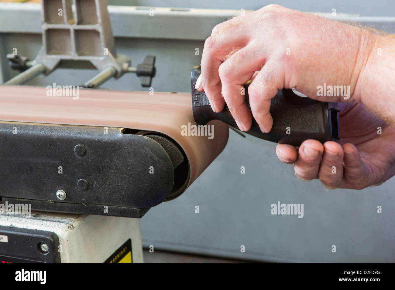 a linisher / belt sander being used Stock Photo Alamy