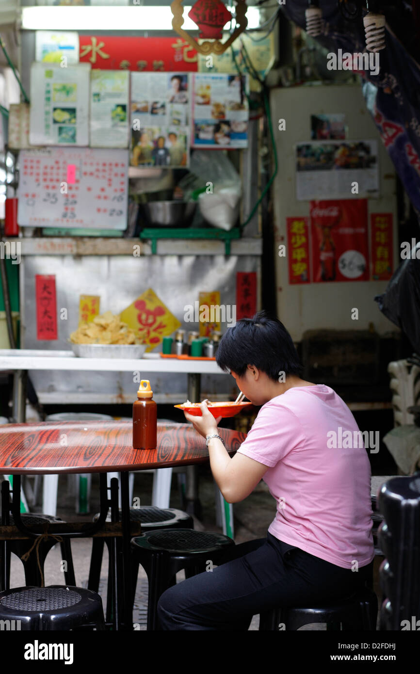 Hong Kong, China, a woman sitting alone in a kitchen in Hong Kong Central Stock Photo