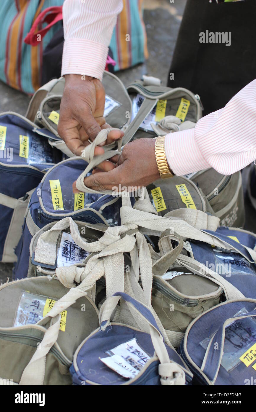 Dabbawalas pack food together for delivery at Andheri Station in Mumbai, India, 20 November 2012. 5,000 food delivers take 175,000 lunches to workplaces every day in Mumbai. Photo: Doreen Fiedler Stock Photo