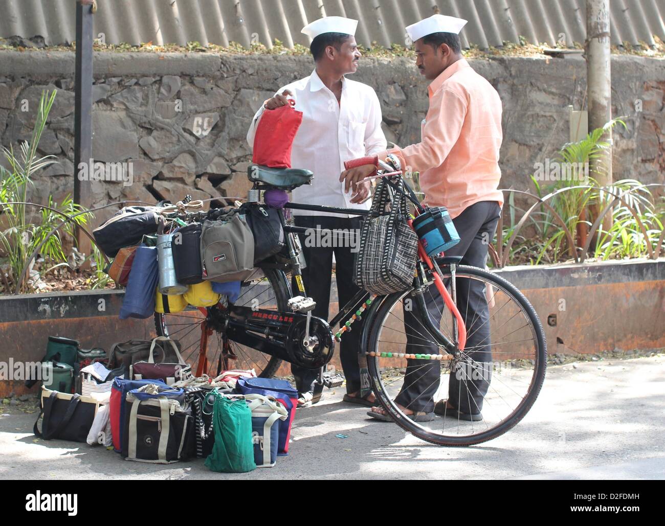 Dabbawalas pack food together for delivery at Andheri Station in Mumbai, India, 20 November 2012. 5,000 food delivers take 175,000 lunches to workplaces every day in Mumbai. Photo: Doreen Fiedler Stock Photo