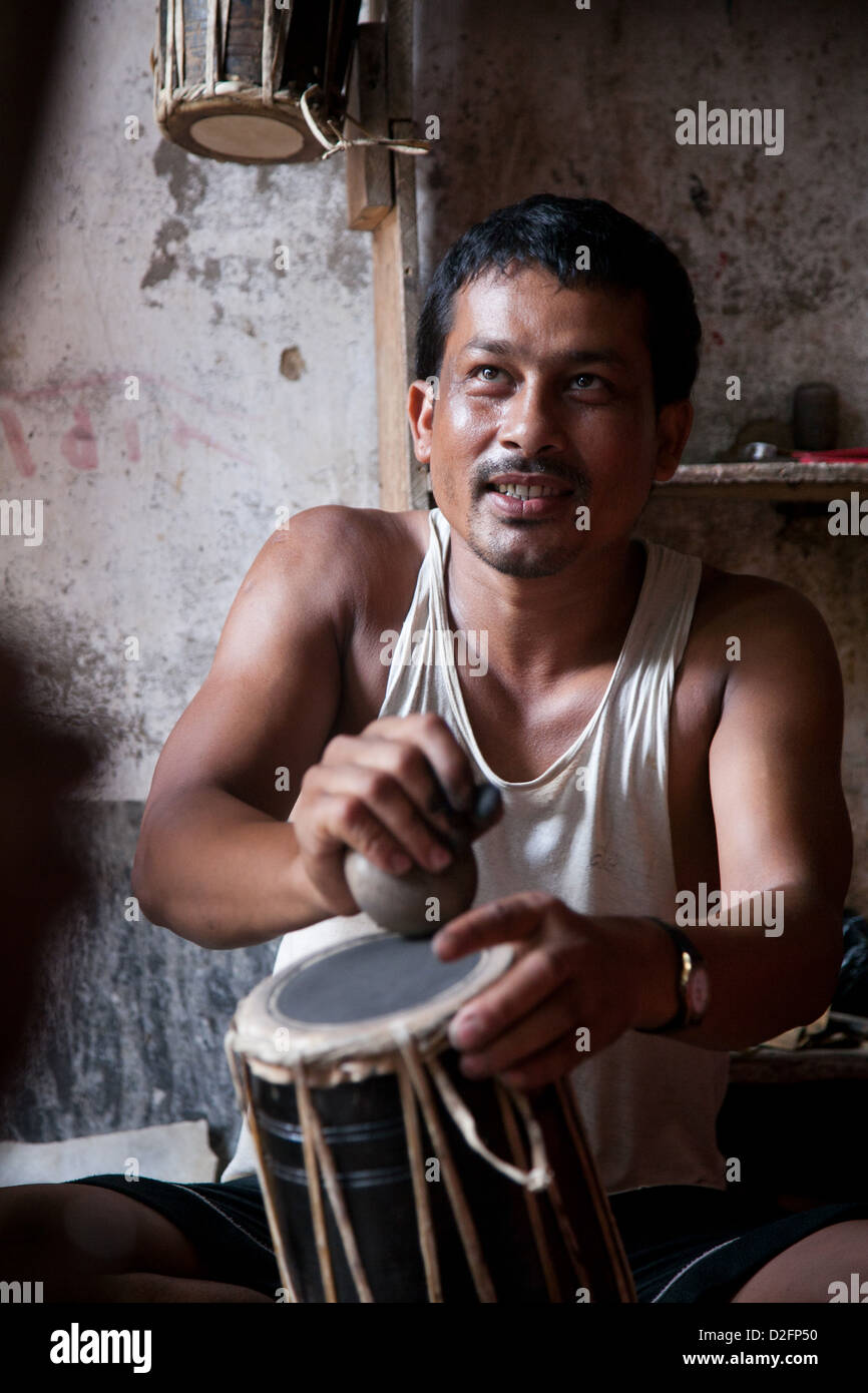 A small drum making factory in Dhading run by husband and wife, assisted by their nephew. The drums are traditional Nepalese. Stock Photo