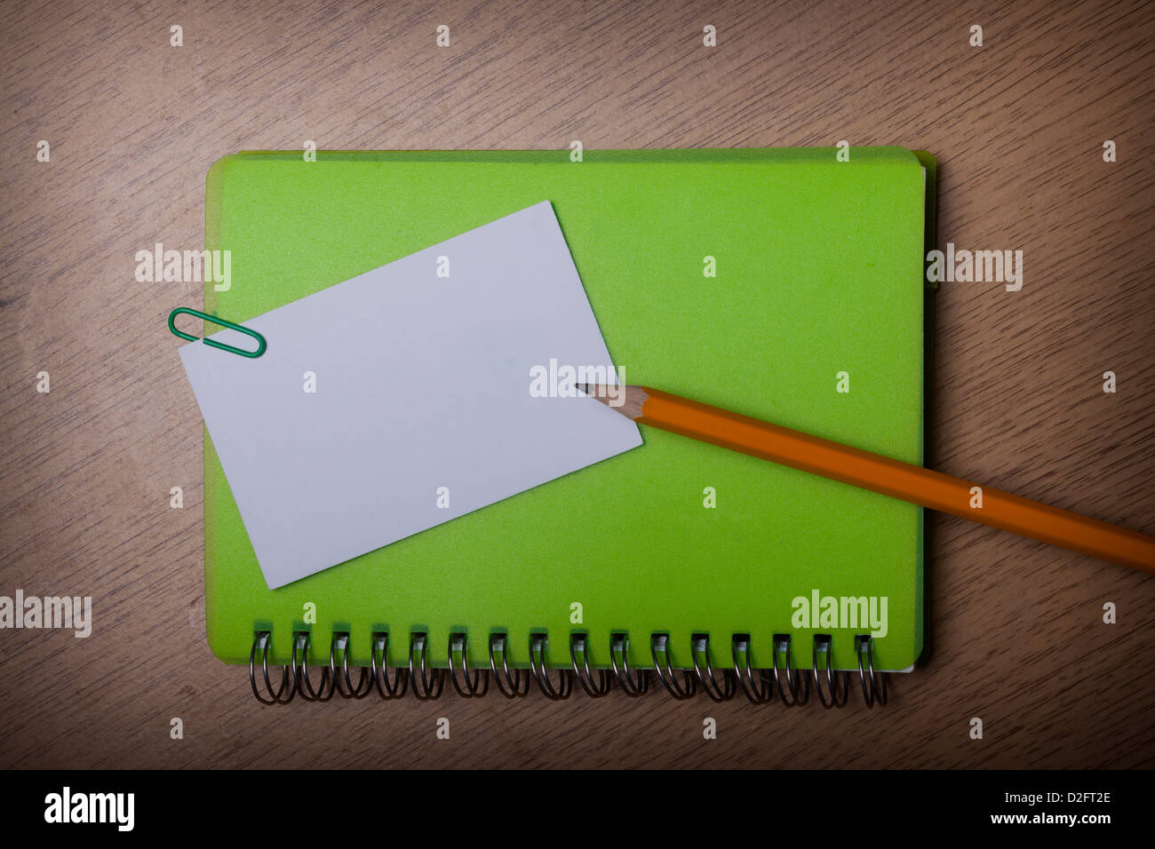green notebook on a wooden desk Stock Photo