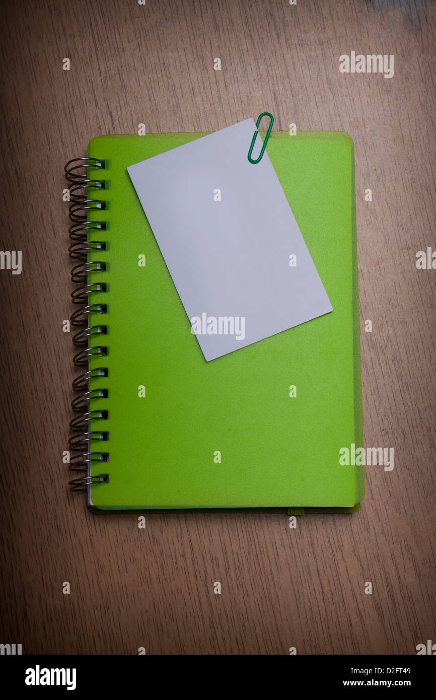 green notebook on a wooden desk Stock Photo