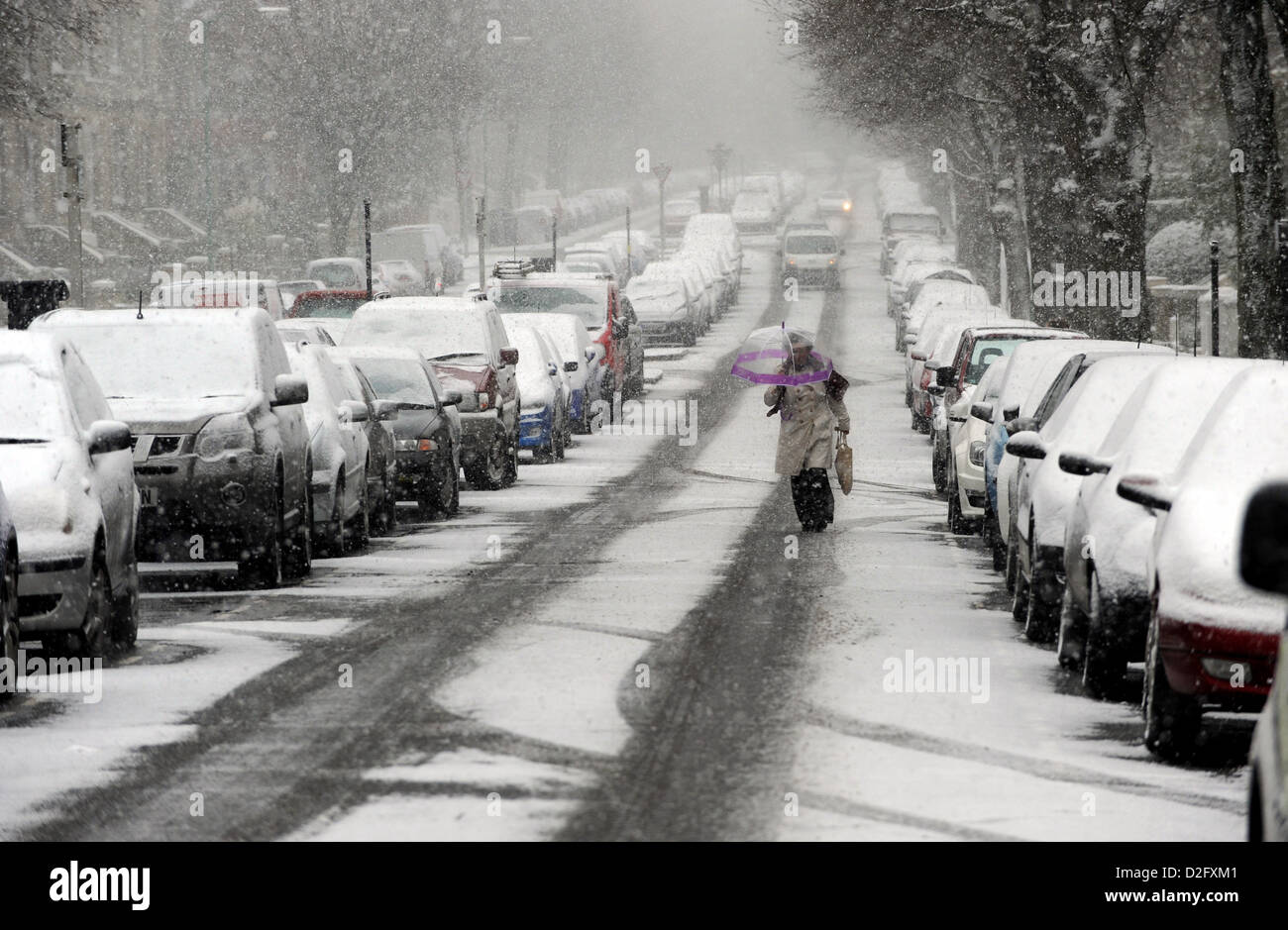 A women walking in the middle of the road after snow and high winds cause blizzard conditions in Brighton Stock Photo