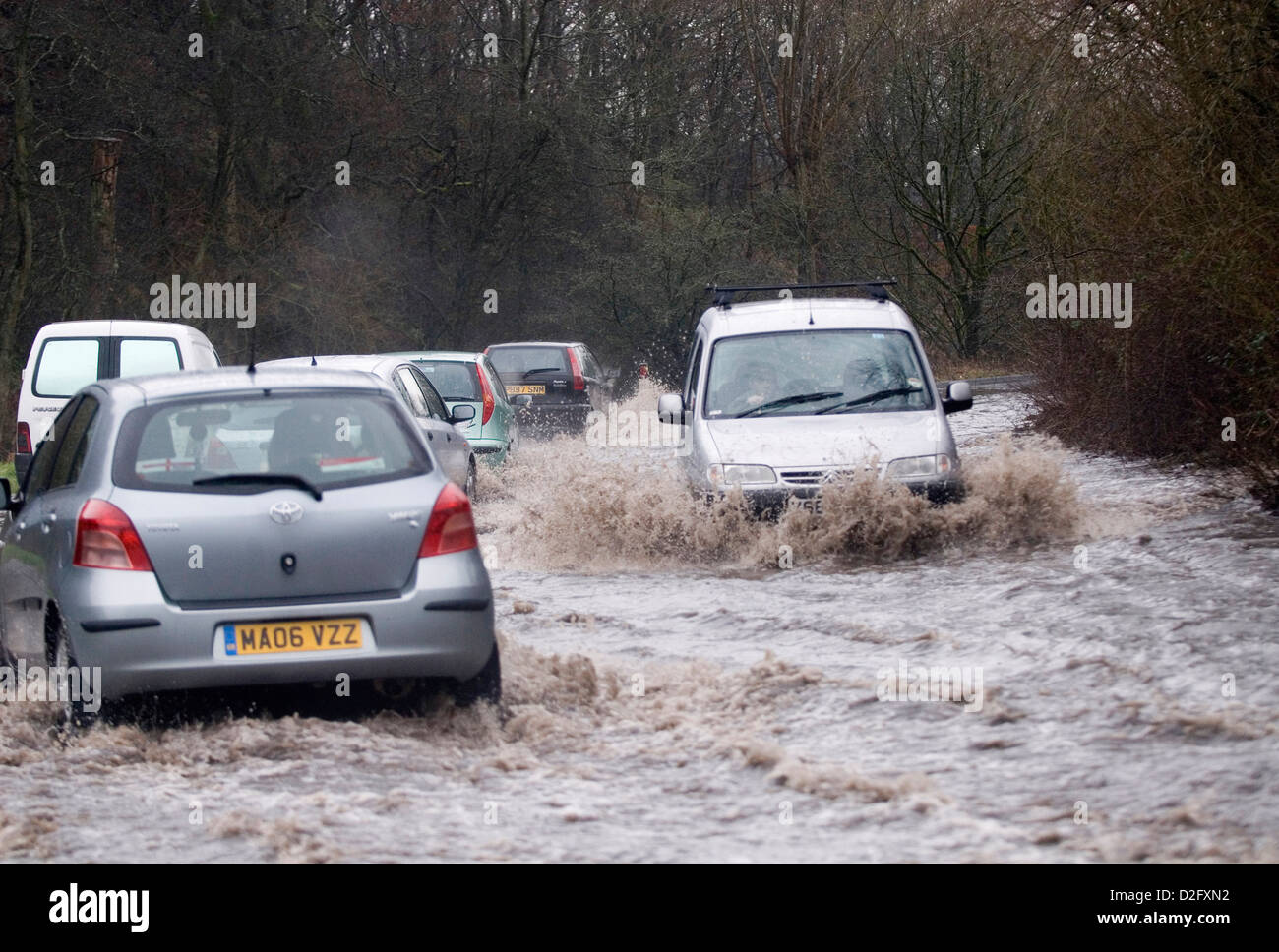 Driving on flooded road, localized flooding, commuting, school run, rush hour, bad weather, Stock Photo