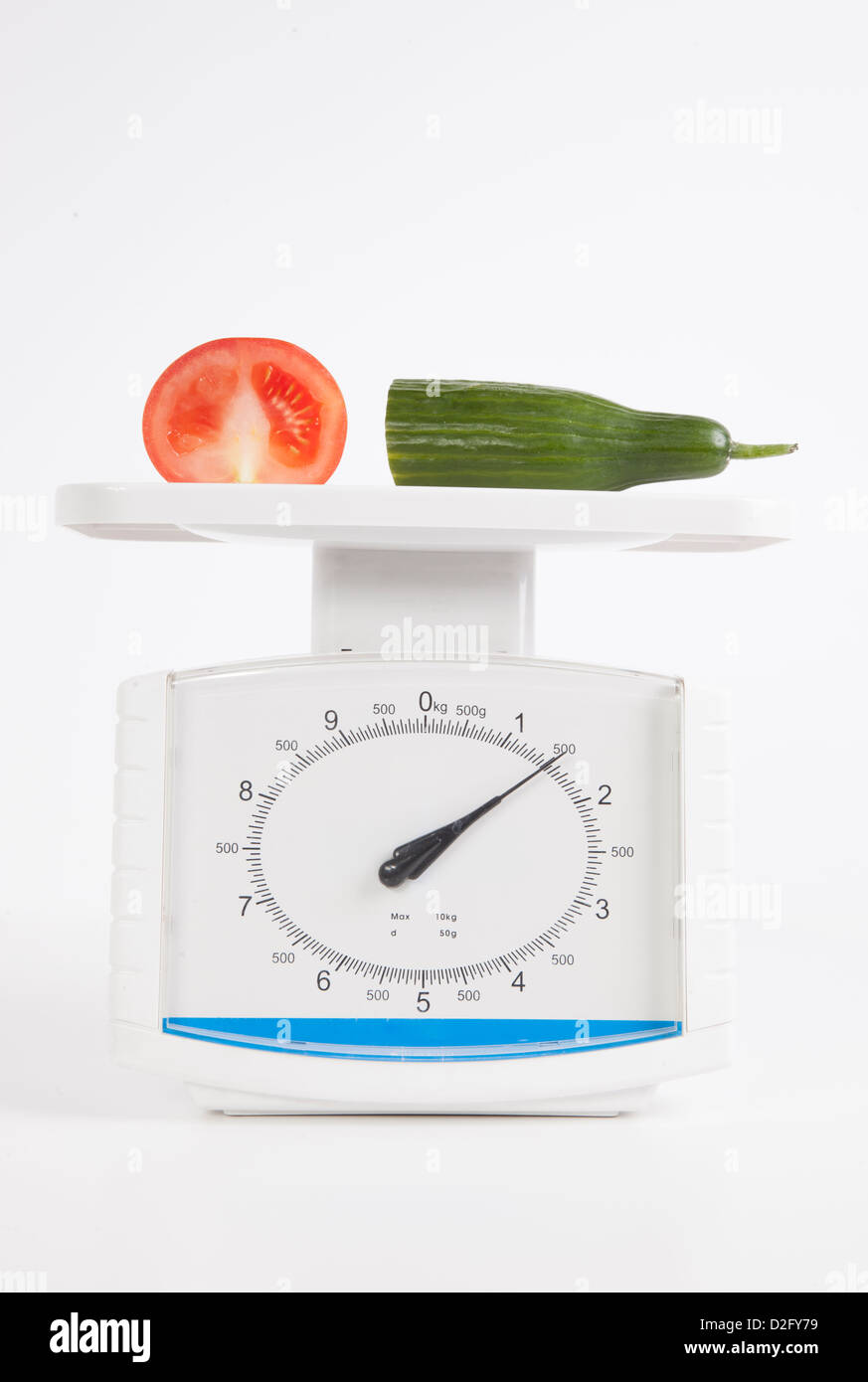 Vegetables measured on scale over white background Stock Photo