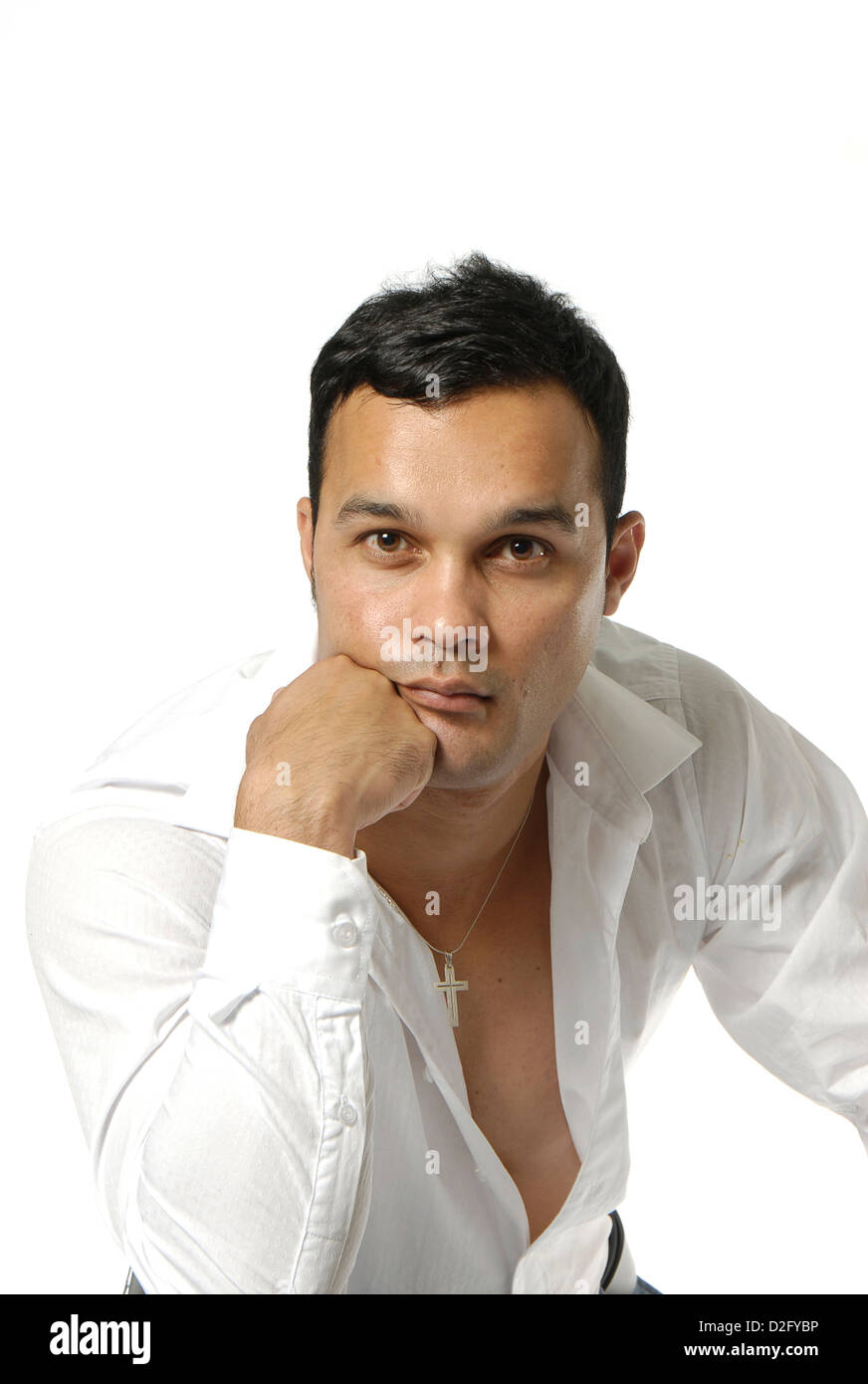 Man with open head on hand looking at camera. Casually dressed with open white shirt and long sleeves Stock Photo