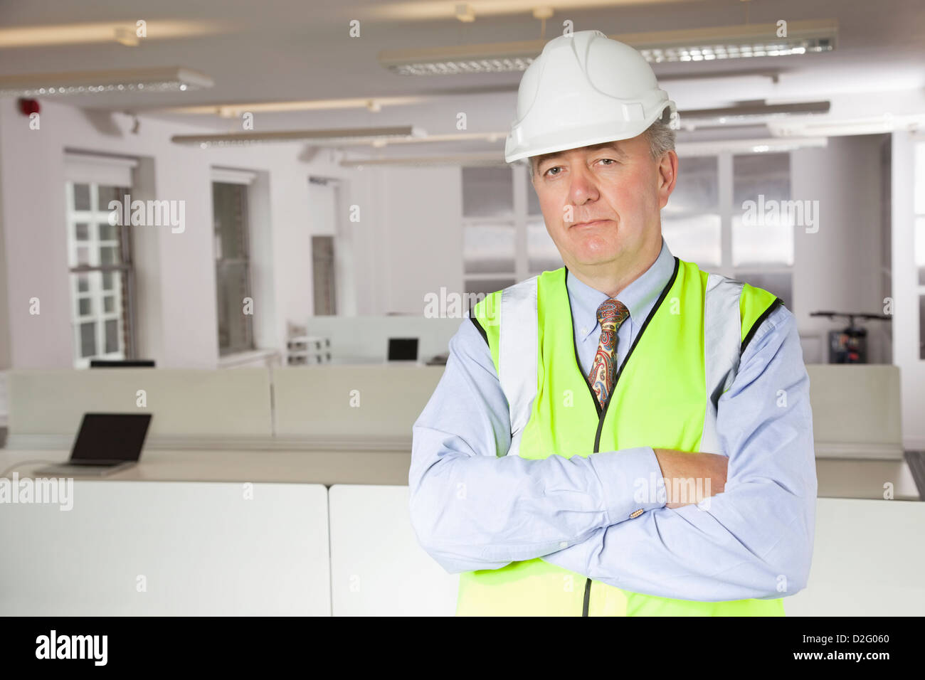 Portrait of middle-aged man in reflector vest and hard hat at office Stock Photo