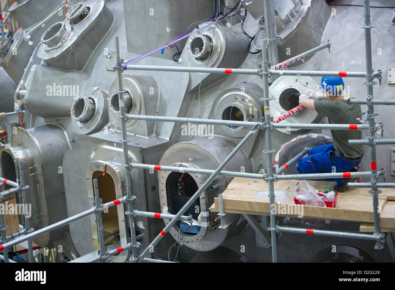 Technicians work on the research reactor 'Wendelstein 7-X' at the Max Planck Institute of Plasma Physics in Greifswald, Germany, 23 January 2013. The reactor will be used for tests on nuclear fusions which are supposed to mirror the processes by which atomic nuclei fuse on the sun and release energy. After environmental protection groups and the green Party voiced security concerns the institute will now operate under the greatest possible transparency. Photo: Stefan Sauer Stock Photo