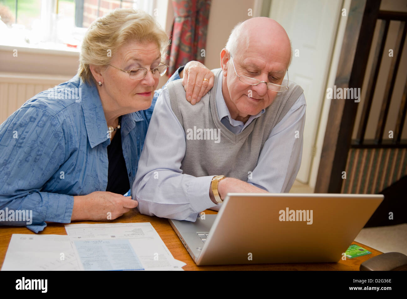 Happy seniors using the internet on a laptop online Stock Photo