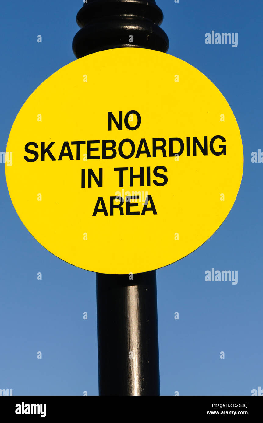 Yellow sign saying 'No skateboarding in this area' Stock Photo