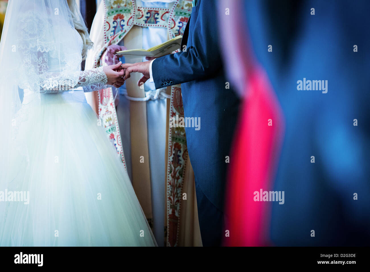 A photo of a Bride and Groom exchanging rings during their wedding vows Stock Photo