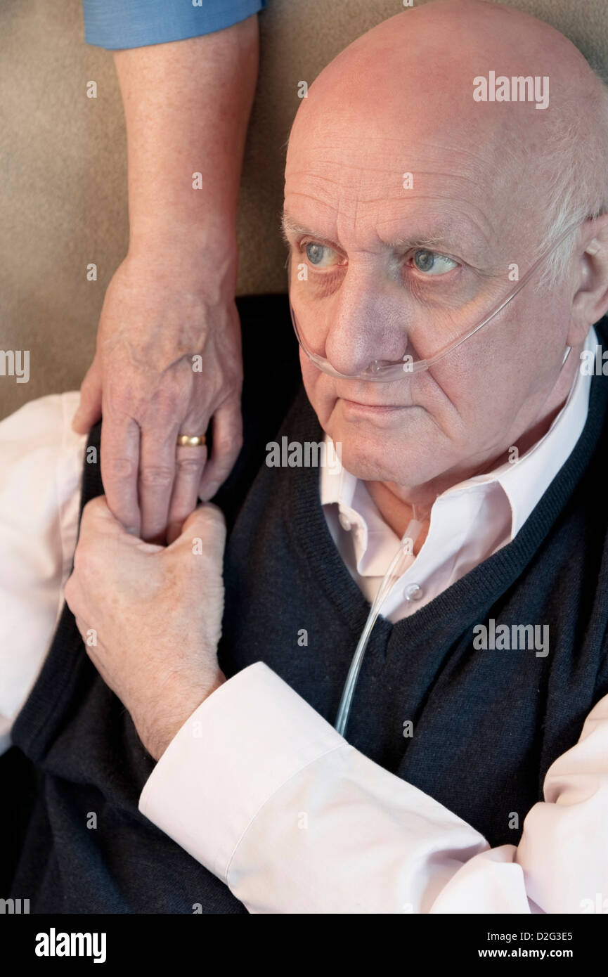 Elderly man in a care home with wife / carer offering a comforting hand of support Stock Photo
