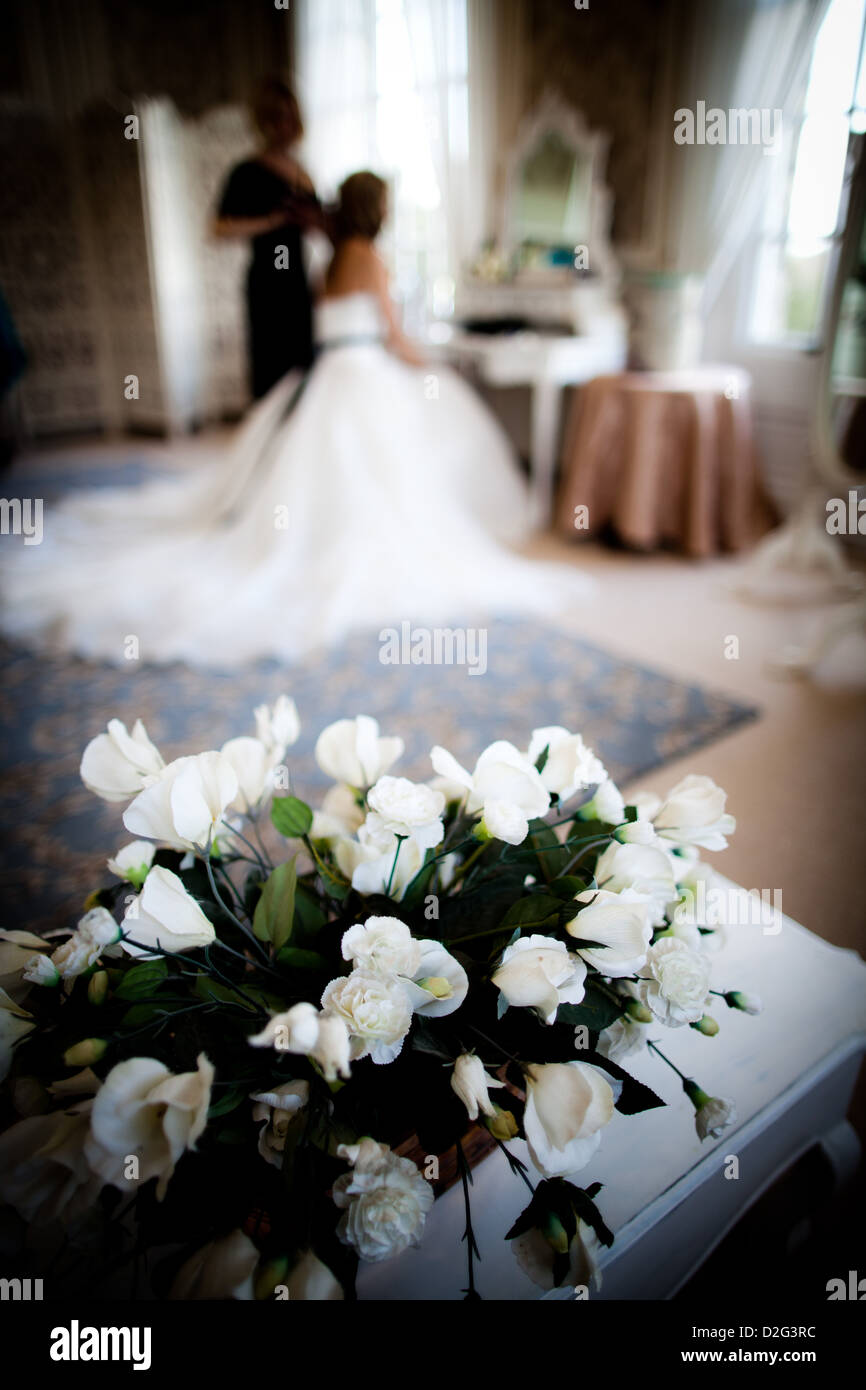 Photo of a bouquet of flowers with a bride sitting blurred in the background. Stock Photo