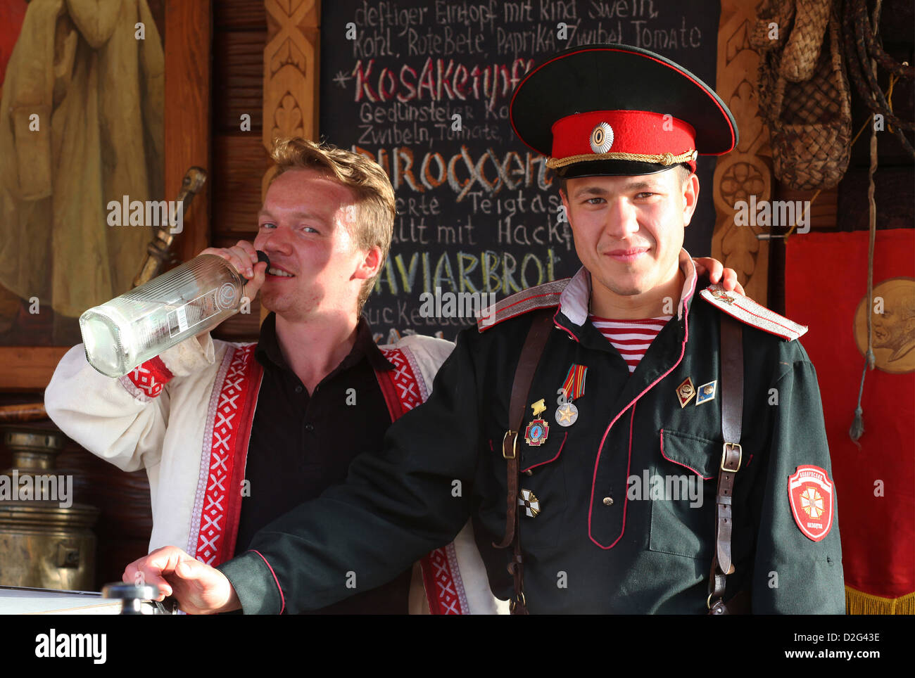 During a festival two local boys from Eastern Europe are serving vodka and other alcoholic drinks behind a beverage stand. Stock Photo