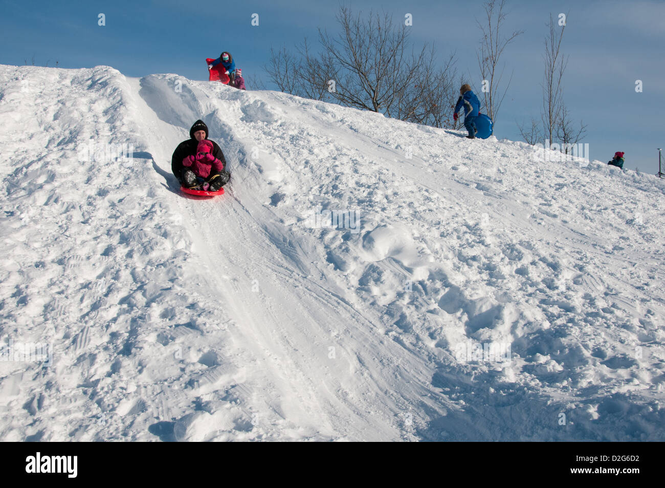People sliding descending on snow hill Jarry Park Montreal Canada Stock
