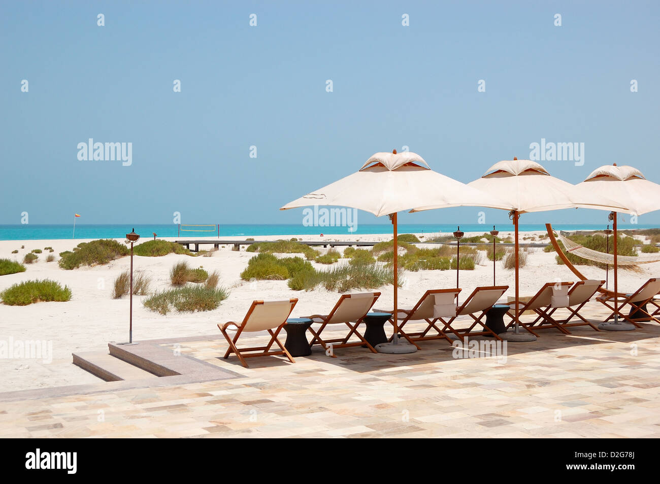 Sunbeds and umbrellas at the beach of luxury hotel, Abu Dhabi, UAE Stock Photo