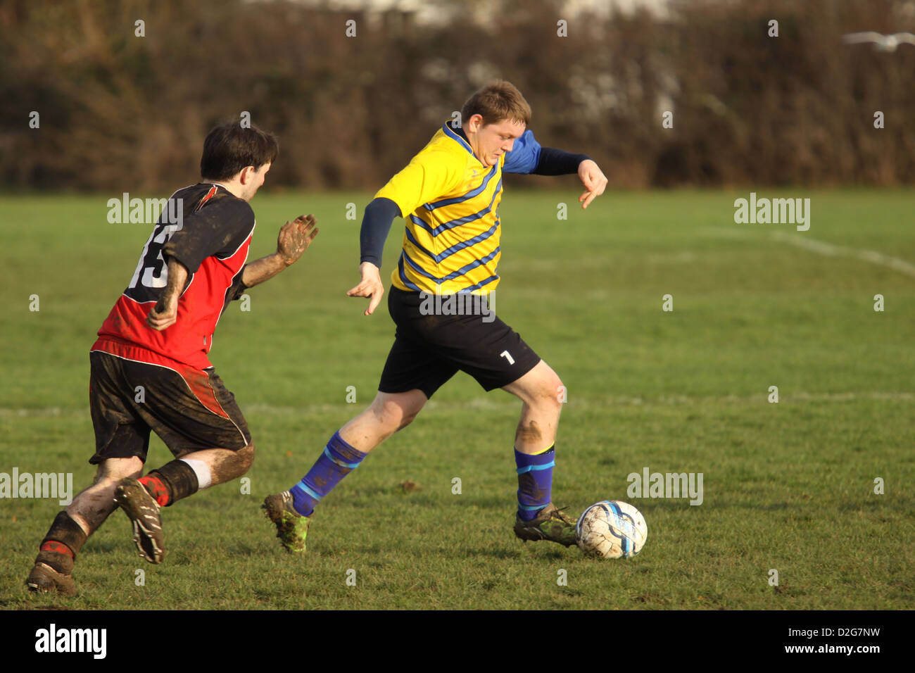 Two men playing football on a sunny afternoon Stock Photo