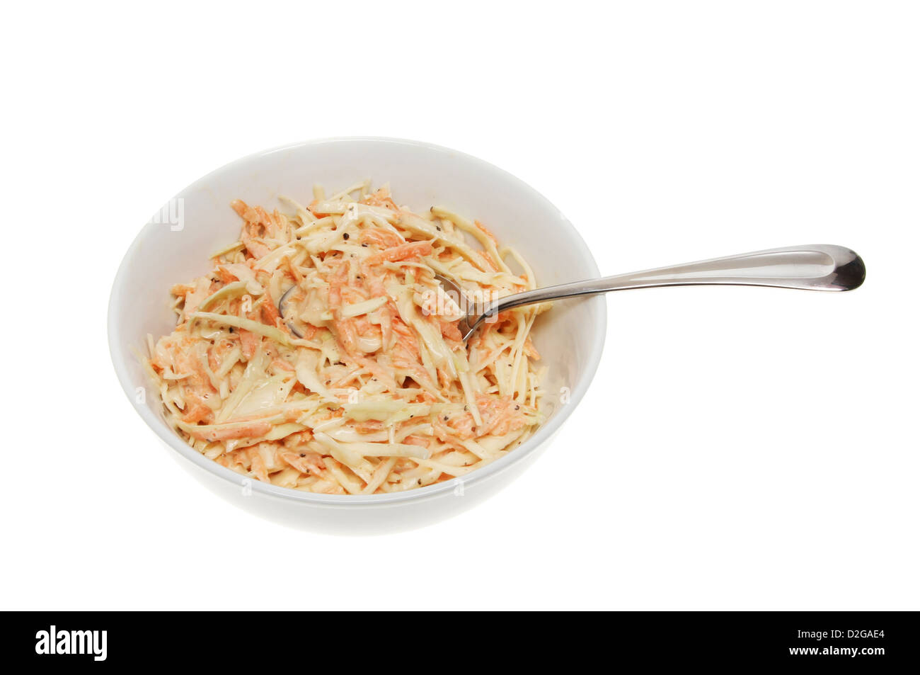 Coleslaw in a bowl with a spoon isolated against white Stock Photo