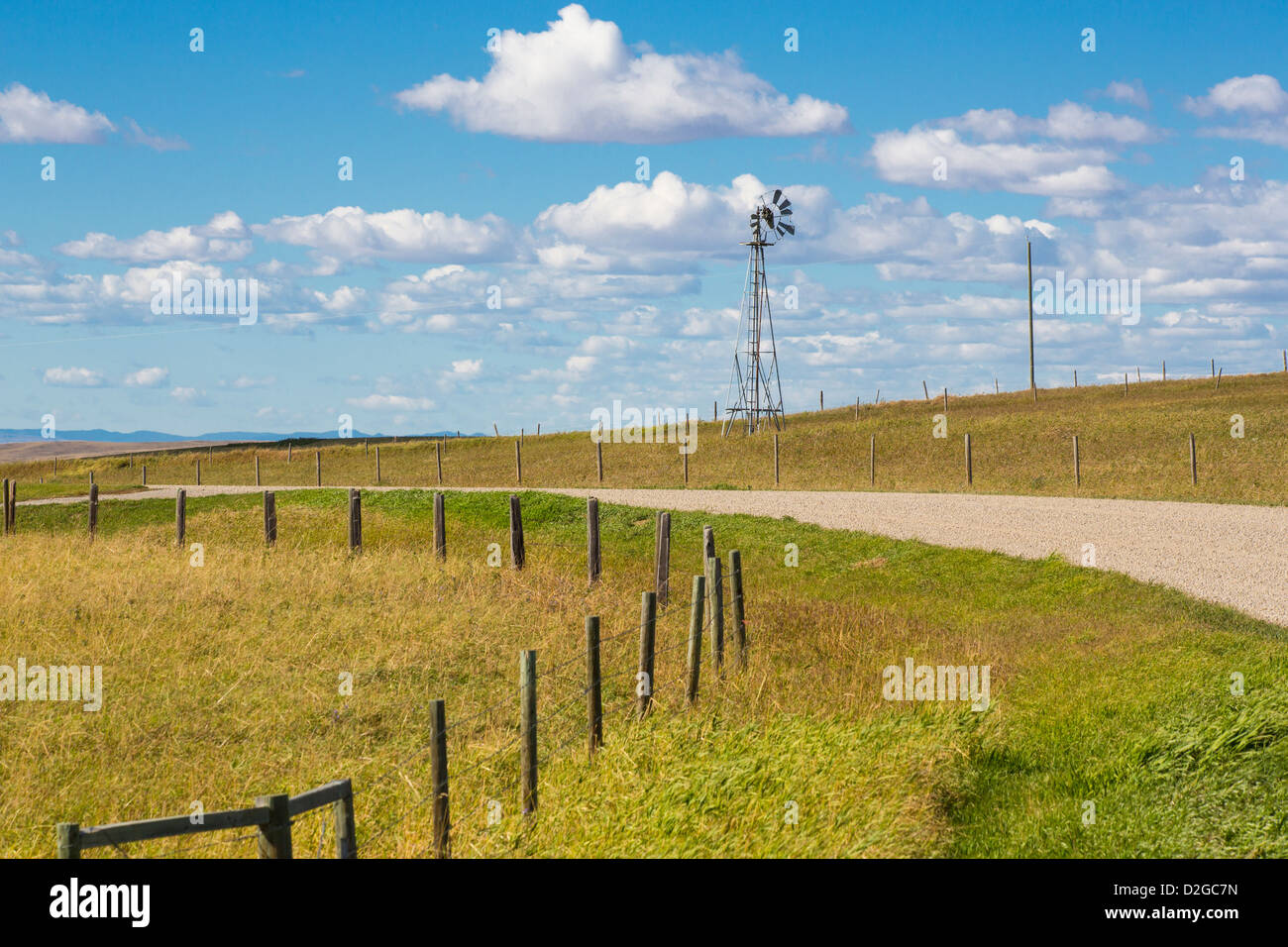 Windmill along dirt road on the prairie of Alberta Canada Stock Photo