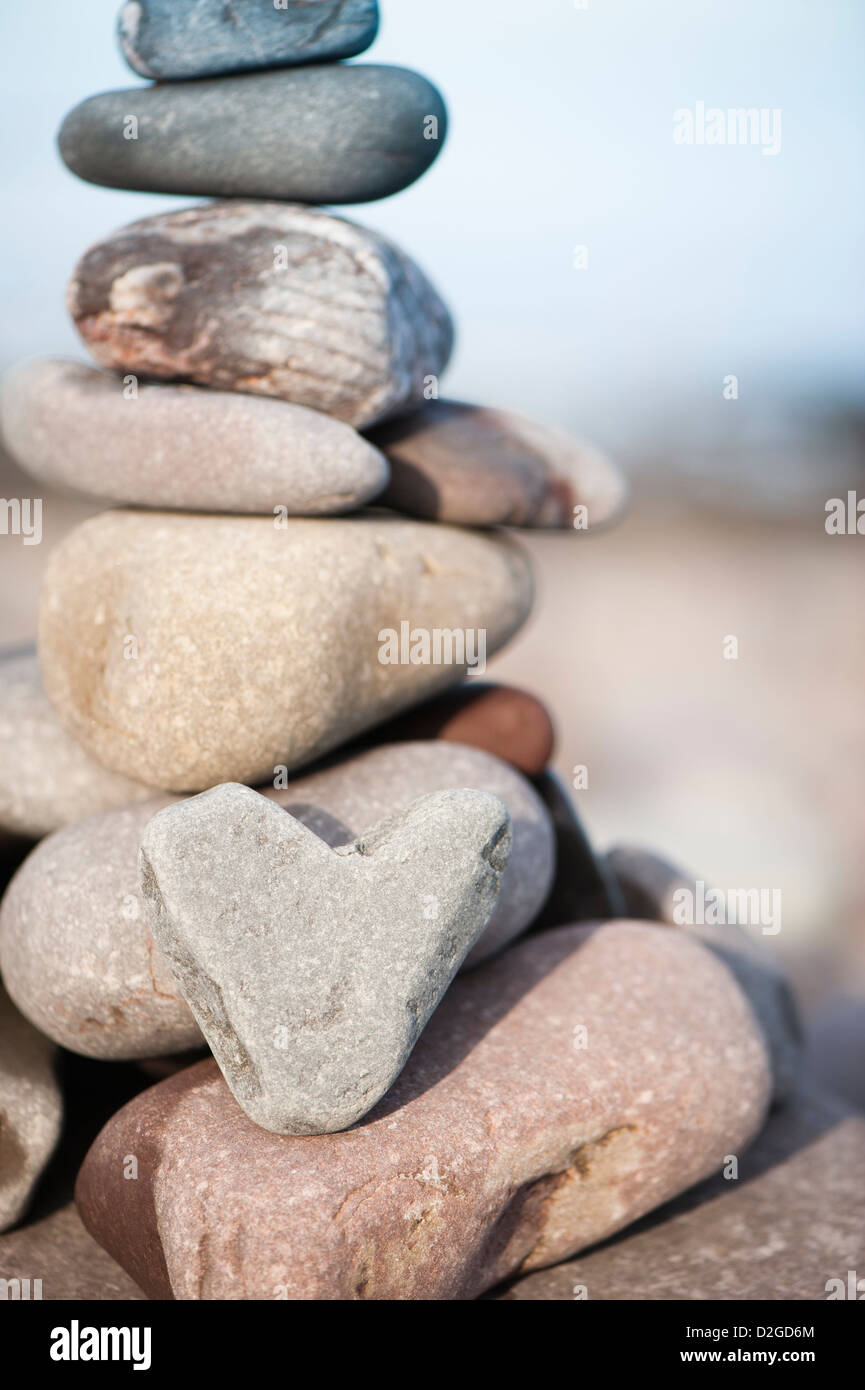 Heart-shaped stone with a stack of stones on the beach at Porlock Weir, Somerset, England, United Kingdom Stock Photo