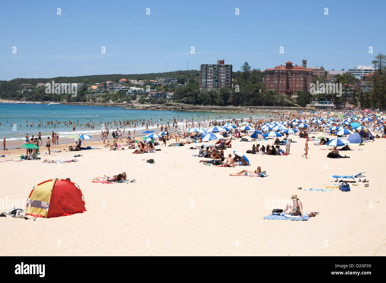 Crowded beach full of sunbathers and swimmers at Australia's iconic Manly Beach Sydney Australia Stock Photo