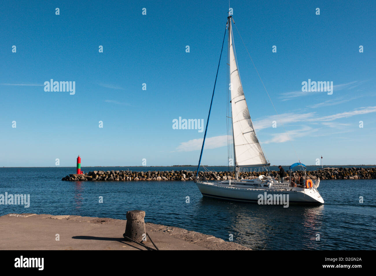 A yacht leaving Marseillan harbour and entering the Etang de Thau Stock Photo