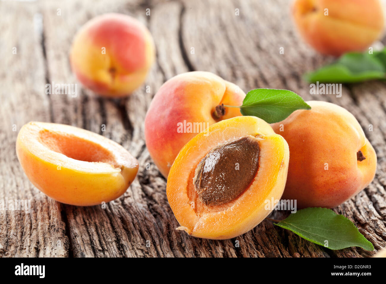 Apricots with leaves on the old wooden table. Stock Photo
