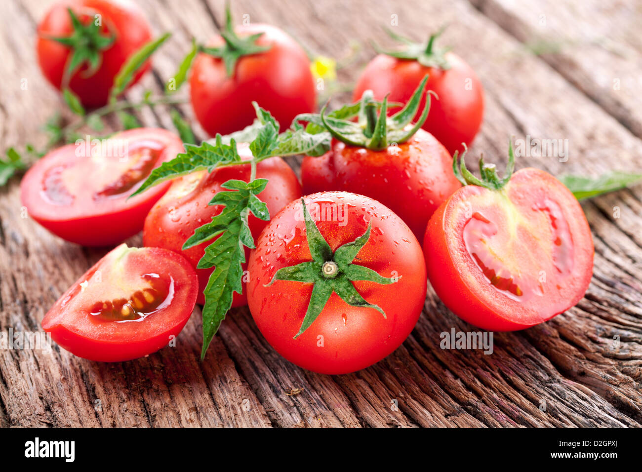 Tomatoes, cooked with herbs for the preservation on the old wooden table. Stock Photo