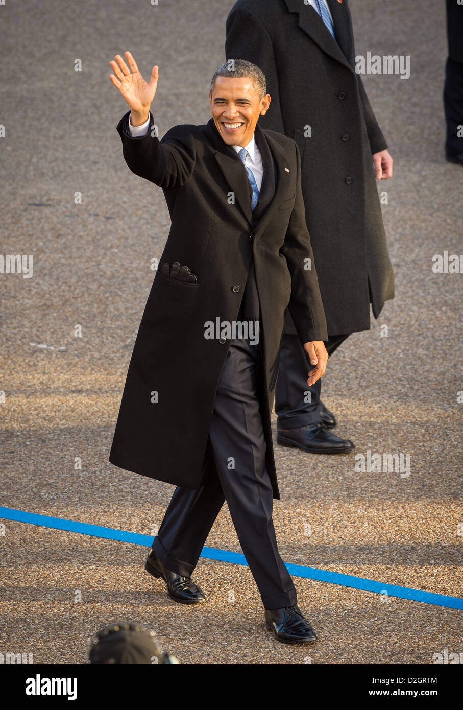 US President Barack Obama waves as he walks along Pennsylvania Avenue during the inaugural parade January 21, 2013 in Washington, DC. Obama was sworn-in as the nation's 44th President earlier in the day. Stock Photo