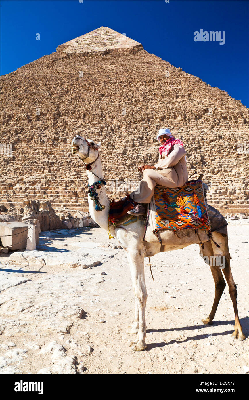 Camel driver poses in front of Pyramid of Khafre/Chefren/Chephren, second-largest Egyptian Pyramid at Giza near Cairo, Egypt. Stock Photo
