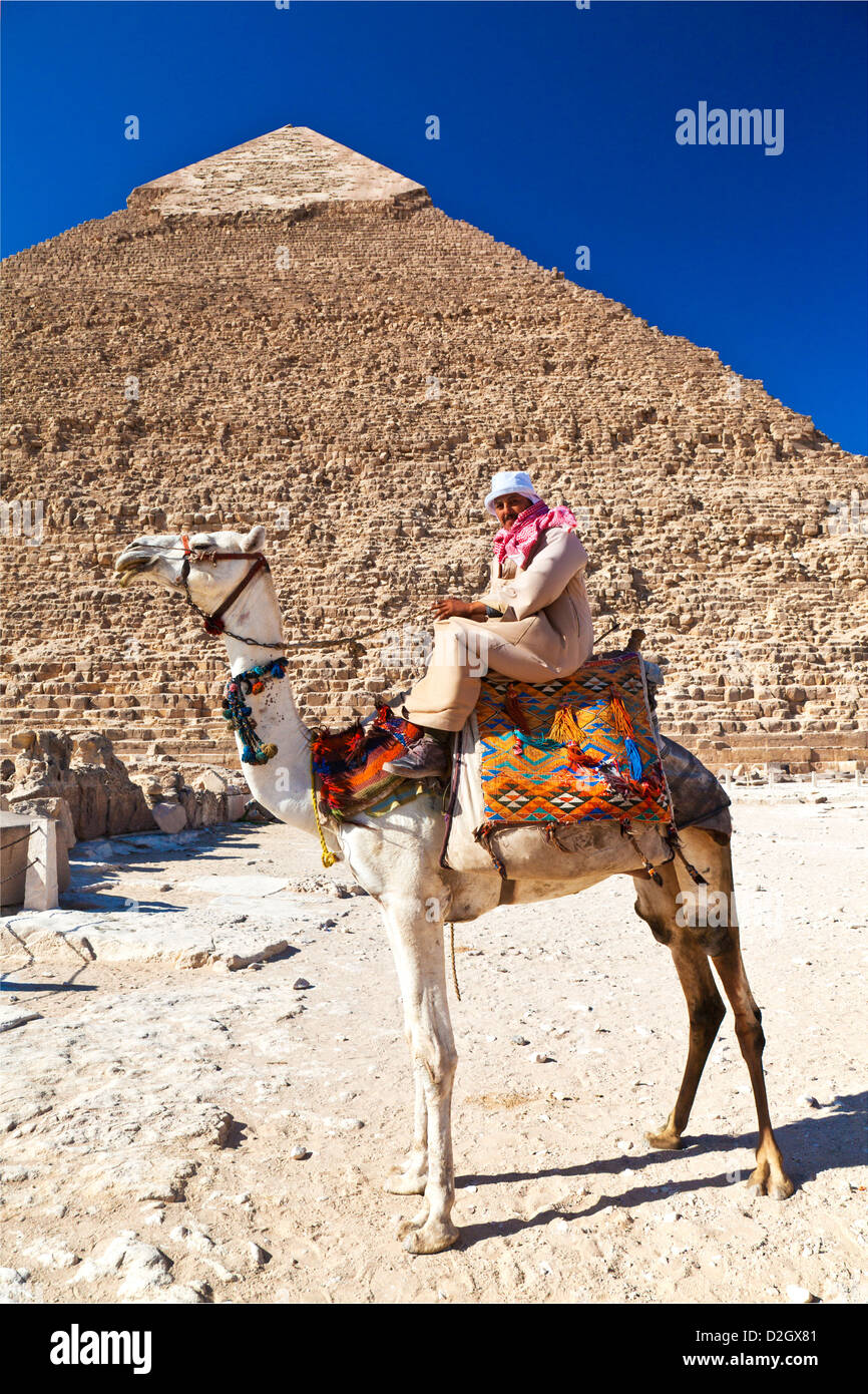 Camel driver poses in front of Pyramid of Khafre/Chefren/Chephren, second-largest Egyptian Pyramid at Giza near Cairo, Egypt. Stock Photo