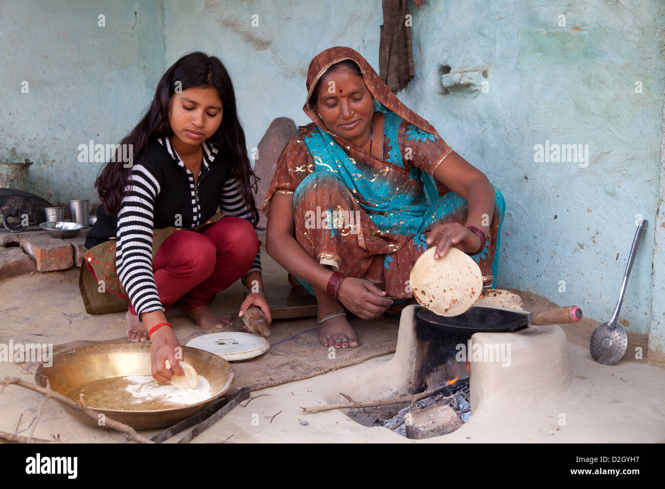 Mother and daughter preparing traditional Indian Roti bread. Model released Stock Photo