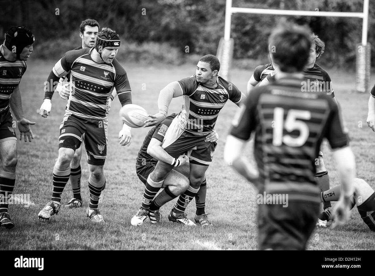 Rugby player being tackled and passing the ball to a team mate at the same time. Stock Photo
