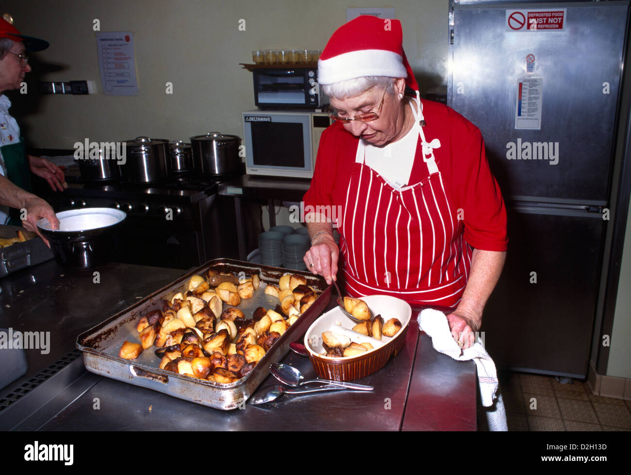 Helper Serving Roast Potatoes Salvation Army Christmas Dinner Sutton Surrey England Stock Photo