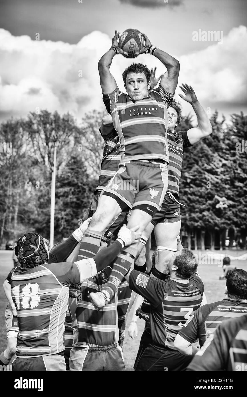 A rugby player jumps for a ball during a line out Stock Photo